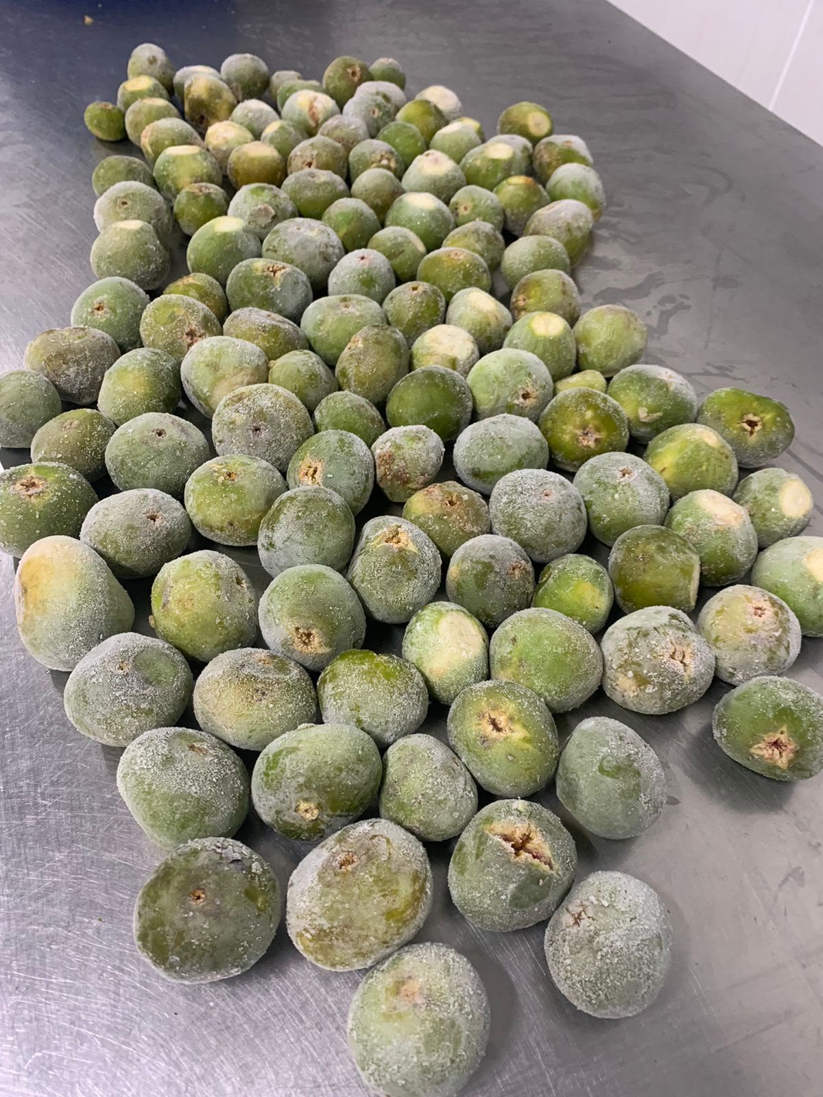 Figues vertes surgelées alignées sur table de tri